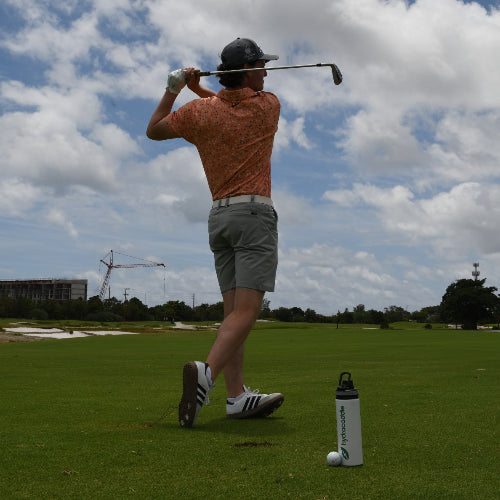 Male golfer completing his swing and featuring hydracaddie sports bottle